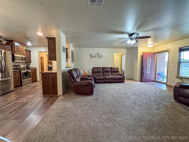 carpeted living room with ceiling fan