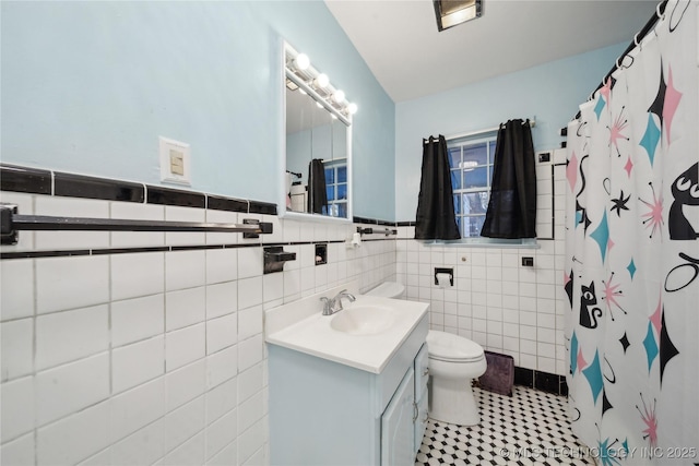 bathroom with tile walls, toilet, vanity, and a shower with shower curtain