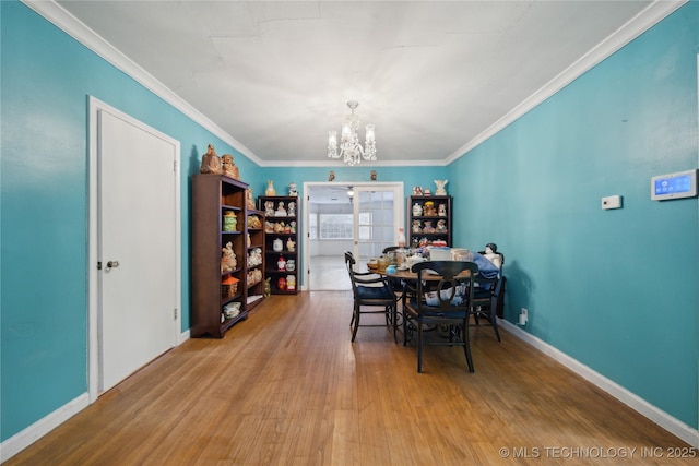 dining area featuring a chandelier, ornamental molding, and hardwood / wood-style floors