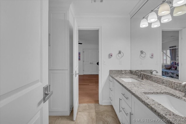 bathroom featuring vanity, an inviting chandelier, tile patterned floors, and crown molding