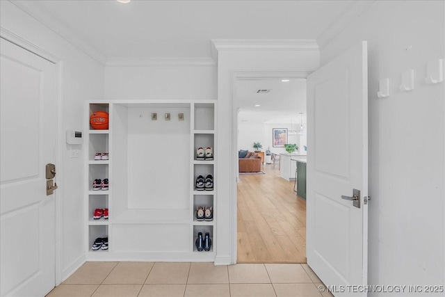 corridor featuring crown molding and light tile patterned flooring