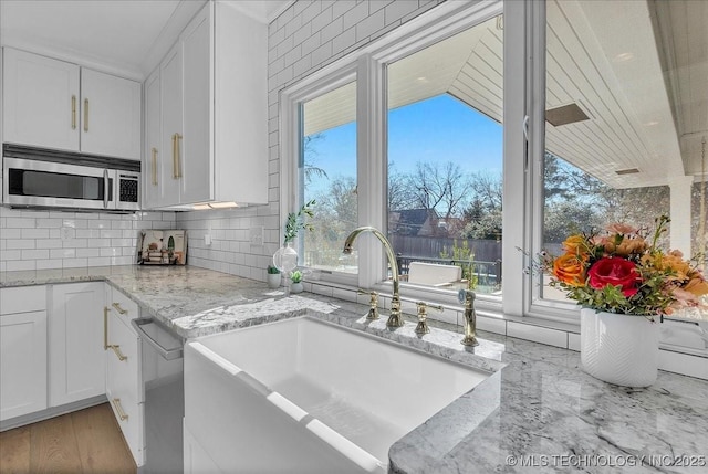 kitchen with white cabinetry, appliances with stainless steel finishes, plenty of natural light, and sink