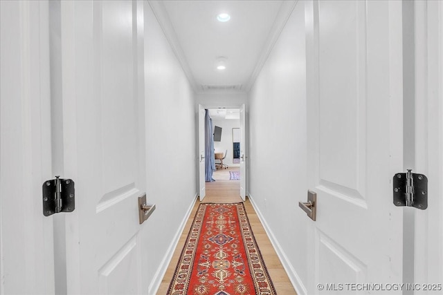 hallway with wood-type flooring and ornamental molding