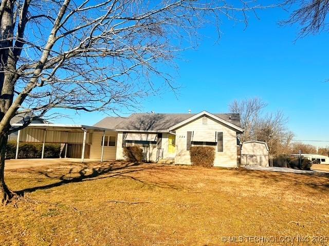 view of front of house with a front lawn and a carport