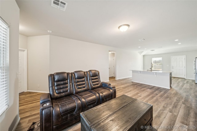 living room with sink and light hardwood / wood-style flooring