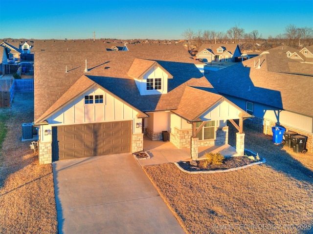 view of front of property featuring a garage and central AC unit