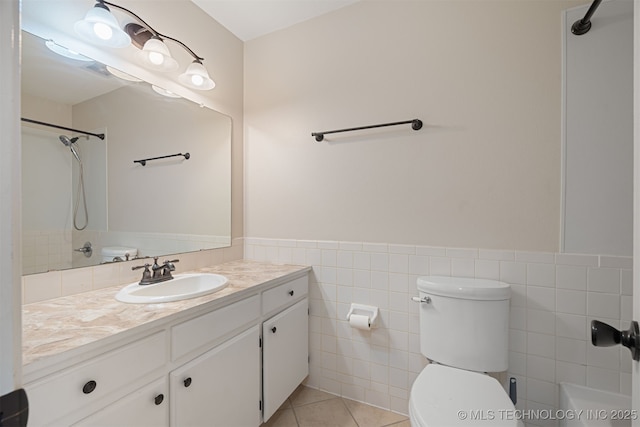 bathroom with toilet, tile walls, tile patterned floors, and vanity