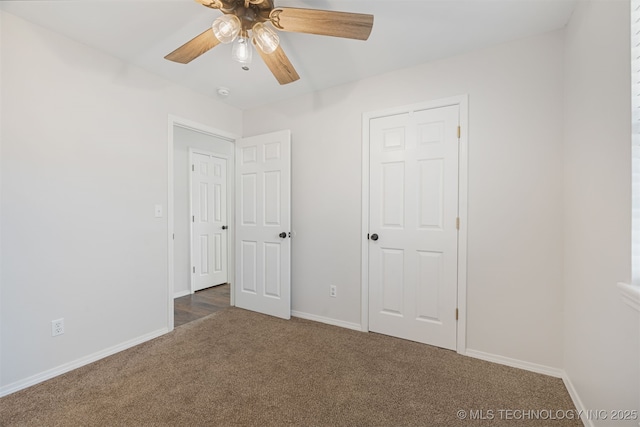 unfurnished bedroom with ceiling fan, a closet, and dark colored carpet