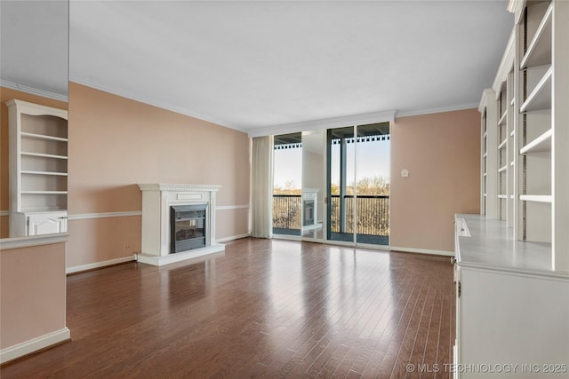 unfurnished living room featuring dark wood-type flooring, ornamental molding, and expansive windows