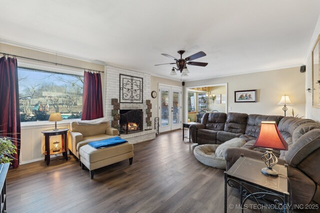 living room featuring french doors, ornamental molding, a healthy amount of sunlight, and dark wood-type flooring