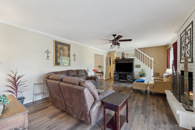 living room featuring crown molding, a brick fireplace, dark wood-type flooring, and ceiling fan