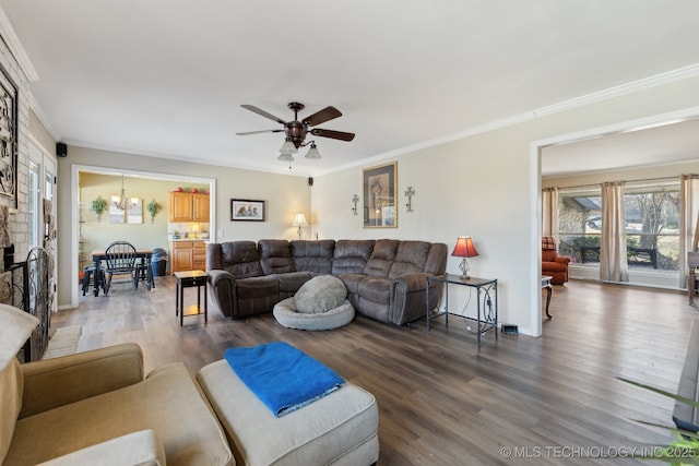 living room with hardwood / wood-style flooring, crown molding, and ceiling fan with notable chandelier