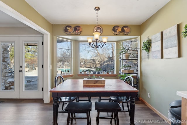 dining area with french doors, dark hardwood / wood-style floors, and a notable chandelier