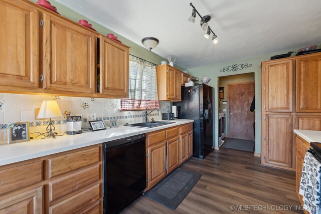 kitchen with backsplash, dark hardwood / wood-style flooring, sink, and black appliances