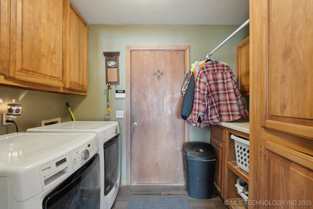 clothes washing area featuring washing machine and dryer and cabinets