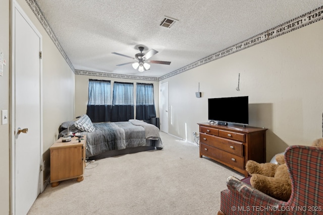 bedroom with a textured ceiling, light colored carpet, and ceiling fan