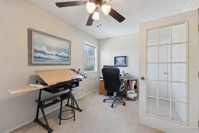 carpeted home office with ceiling fan and a textured ceiling