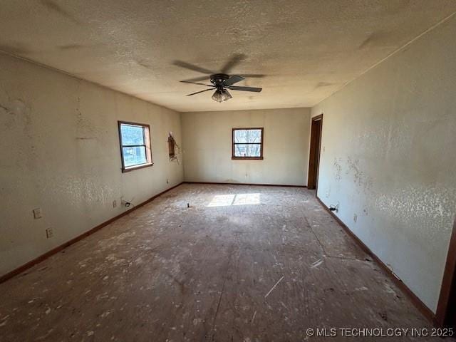 spare room with ceiling fan, a textured ceiling, and a healthy amount of sunlight