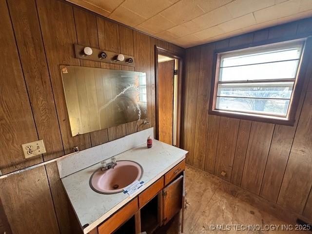 bathroom featuring vanity and wood walls