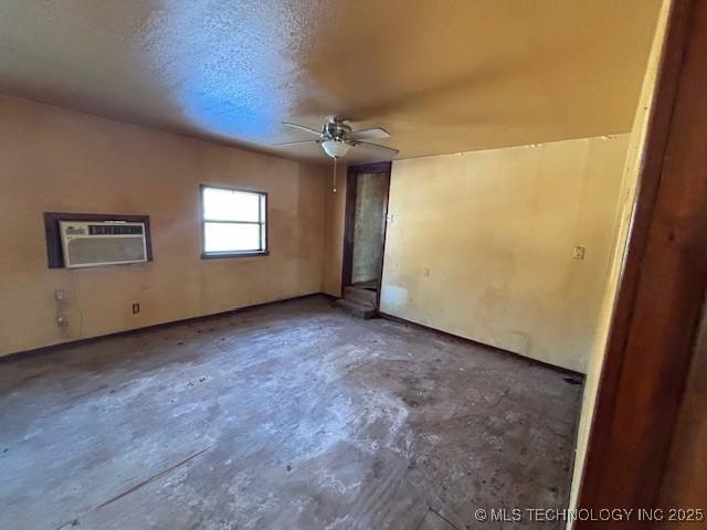 unfurnished room featuring a textured ceiling, ceiling fan, and a wall unit AC