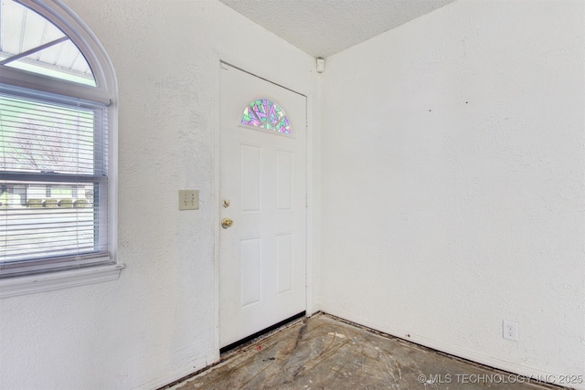 foyer entrance with a textured ceiling