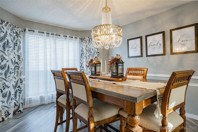 dining area featuring a chandelier, a textured ceiling, and hardwood / wood-style floors