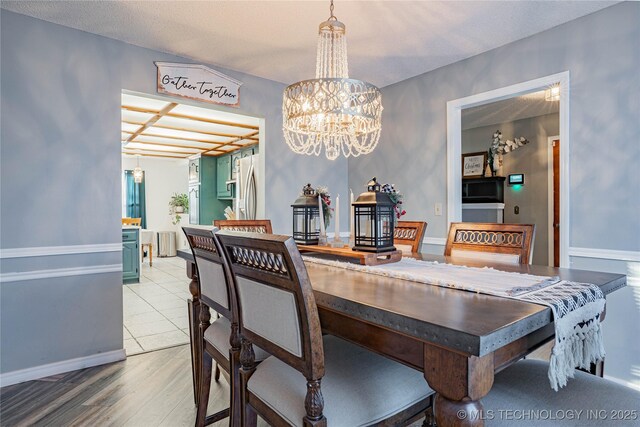 dining room featuring hardwood / wood-style floors, a textured ceiling, and a chandelier