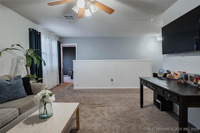 carpeted living room with ceiling fan and a textured ceiling