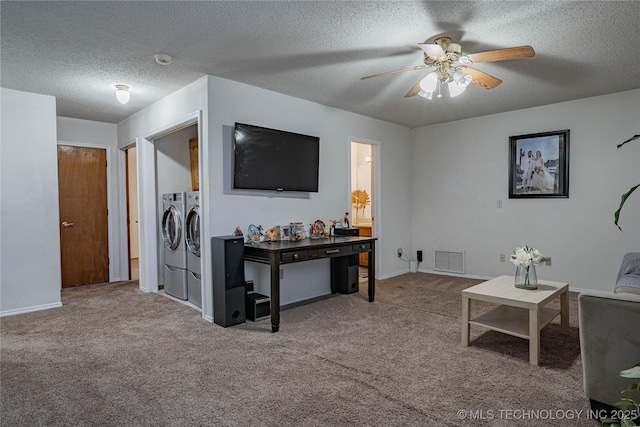 living room with a textured ceiling, ceiling fan, carpet flooring, and washer and clothes dryer