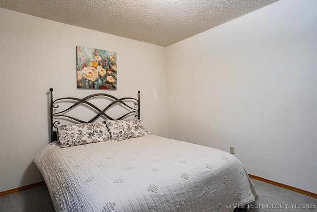 bedroom featuring a textured ceiling and carpet flooring