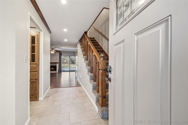 hallway with light tile patterned floors and ornamental molding