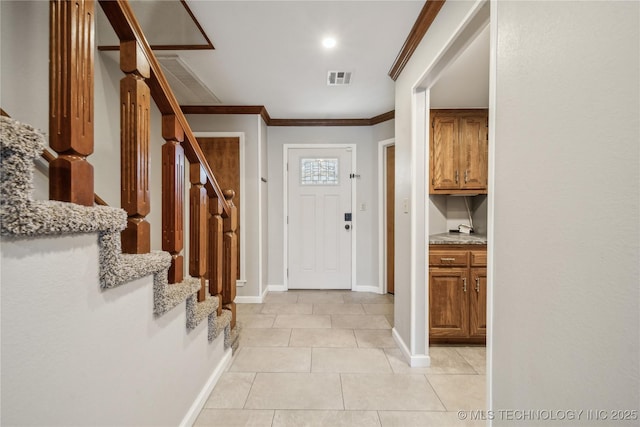 tiled entryway featuring crown molding