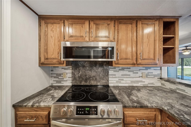 kitchen featuring decorative backsplash, stainless steel appliances, and dark stone countertops