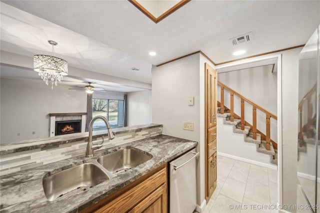 kitchen with decorative light fixtures, ceiling fan, dishwasher, decorative backsplash, and sink