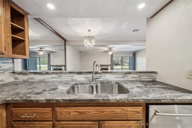 kitchen with decorative backsplash, sink, a wealth of natural light, and a chandelier