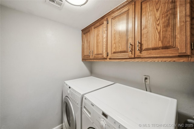 laundry area featuring washer and dryer and cabinets