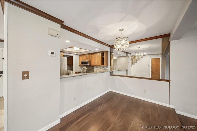 unfurnished dining area featuring dark hardwood / wood-style floors, a raised ceiling, crown molding, and a notable chandelier