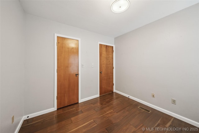 unfurnished bedroom featuring a closet and dark hardwood / wood-style flooring