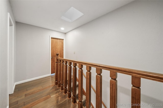 hallway with dark hardwood / wood-style flooring and a skylight