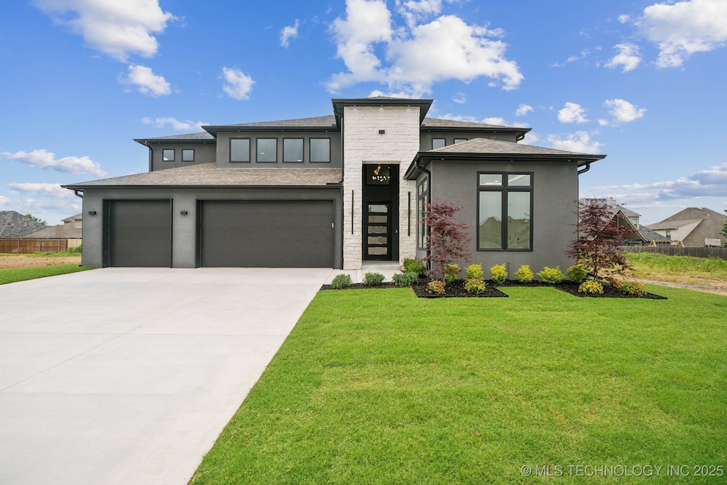 prairie-style home with a front lawn and a garage