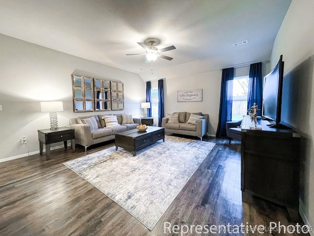 living room featuring ceiling fan and dark wood-type flooring