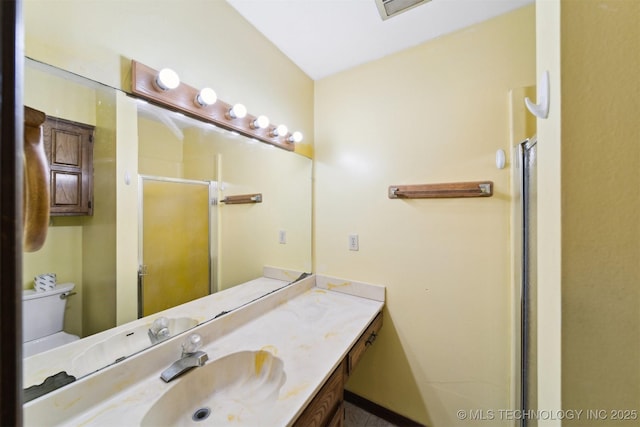 bathroom with a shower with shower door, toilet, and vanity