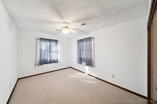 carpeted empty room featuring ceiling fan and a textured ceiling