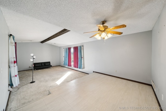 empty room featuring lofted ceiling with beams, carpet floors, a textured ceiling, and a ceiling fan