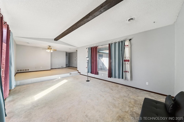 spare room featuring a textured ceiling, ceiling fan, light colored carpet, and lofted ceiling with beams