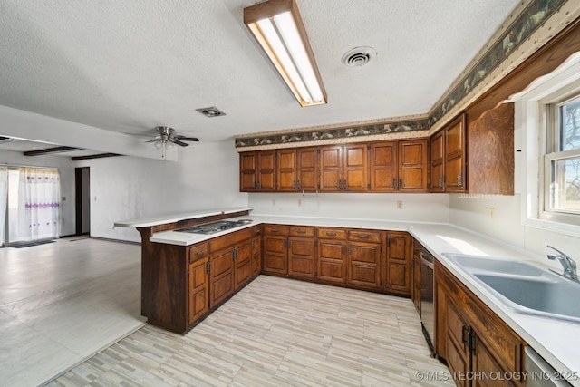 kitchen featuring a sink, visible vents, a peninsula, and light countertops