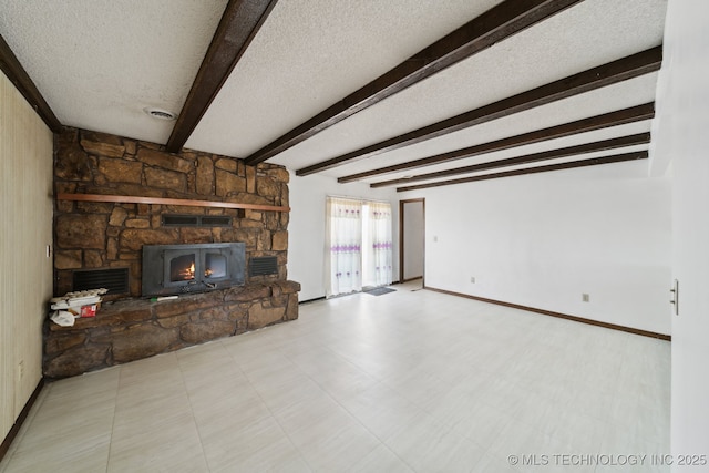 unfurnished living room with visible vents, beam ceiling, a textured ceiling, a fireplace, and baseboards