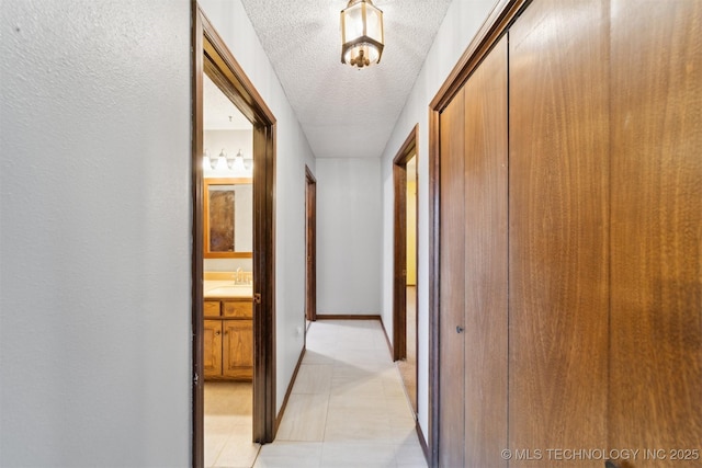 hall featuring sink and a textured ceiling