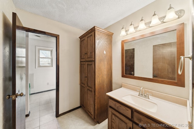 bathroom with baseboards, a textured ceiling, vanity, and tile patterned flooring