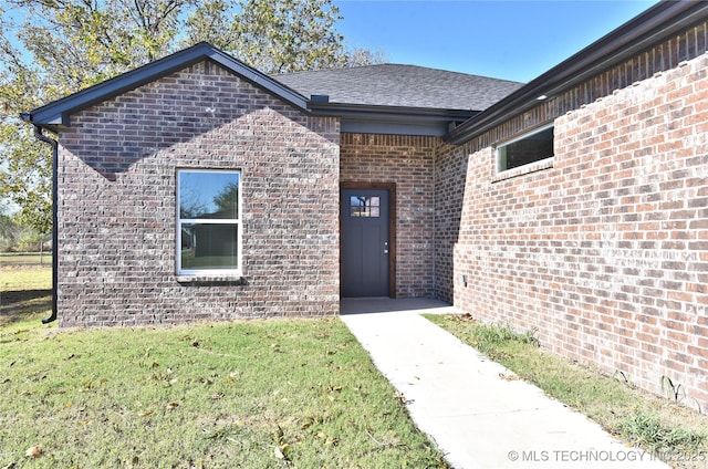 view of exterior entry featuring a yard